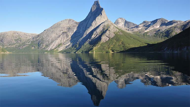 Fjell som speiler seg i vannet